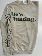 Load image into Gallery viewer, Stay cozy and stylish this season with our tan "He’s Hunting" sweater! Crafted from our Laviva Sport Soft material, this comfy piece not only keeps you warm but also answers that dreaded question of where your significant other is. With the Muscadine Ridge logo gracefully running down the right sleeve, you’ll showcase your love for the outdoors while looking effortlessly chic. Perfect for those crisp days out or lounging at home, this sweater is a must-have for every hunting enthusiast's partner. Grab yours